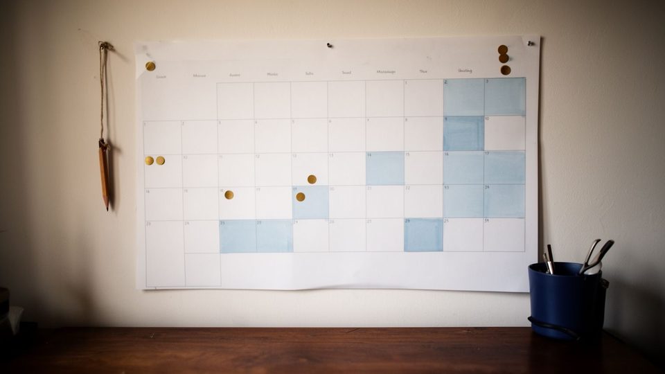 Illustration: a blank wall planner with some days shaded and a few dot stickers